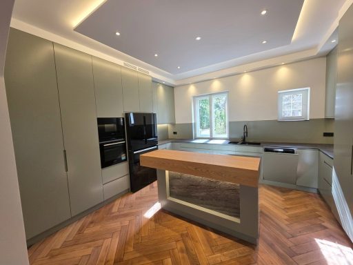 Luxuriöse Einbauküche mit Kochinsel aus Massivholz, indirekter Deckenbeleuchtung und deckenhohen Einbauschränken