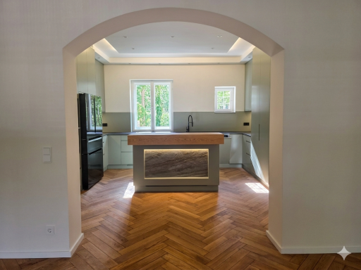 Luxuriöse Einbauküche mit Kochinsel aus Massivholz, indirekter Deckenbeleuchtung und deckenhohen Einbauschränken